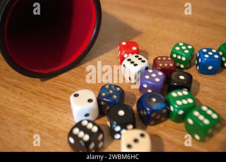 Dice spilling from black dice cup Stock Photo