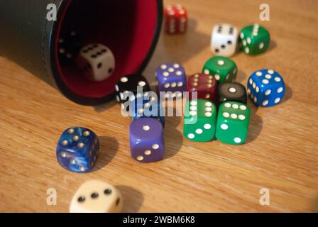 Dice spilling from black dice cup Stock Photo