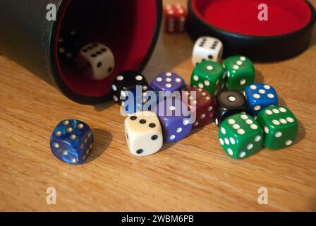 Dice spilling from black dice cup Stock Photo