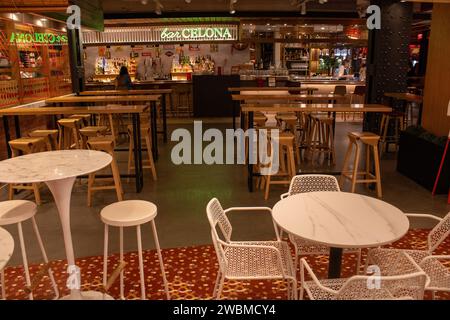 A well-lit room showcases a variety of wooden tables and chairs neatly arranged in groups, perfect for any gathering Stock Photo