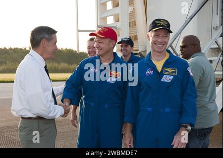 CAPE CANAVERAL, Fla. -- NASA Kennedy Space Center Director Bob Cabana, left, congratulates STS-135 Pilot Doug Hurley on the successful STS-135 mission to the International Space Station. Next to Hurley is Commander Chris Ferguson, and behind him are Mission Specialists Sandy Magnus, left, and Rex Walheim. The final four astronauts of NASA's Space Shuttle Program brought space shuttle Atlantis home to the Shuttle Landing Facility's Runway 15 at NASA's Kennedy Space Center in Florida at 5:57 a.m. EDT. Atlantis' final return from space completed a 13-day, 5.2-million-mile journey to the Internati Stock Photo
