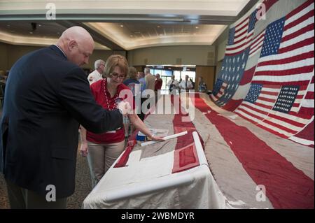 CAPE CANAVERAL, Fla. -- Joe Dowdy, special operations manager at NASA's Kennedy Space Center, contributes stitches to the 'National 9/11 Flag' during a ceremony in the Debus Conference Facility at the Kennedy Space Center Visitor Complex in Florida. The contributions of NASA, Kennedy Space Center and the state of Florida were stitched into the fabric of the American Flag, which was recovered near ground zero following the World Trade Center attacks on Sept. 11, 2001.    The 'New York Says Thank You Foundation' is taking the flag on a cross-country journey to be restored to its original 13-stri Stock Photo