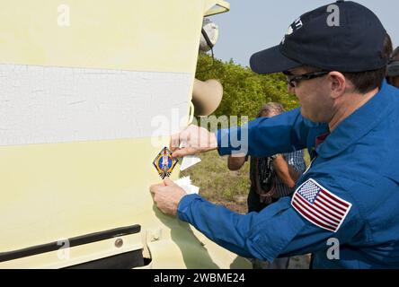 CAPE CANAVERAL, Fla. -- Mission Specialist Rex Walheim affixes his mission's logo on an M113 armored personnel carrier during training at NASA's Kennedy Space Center in Florida . It's tradition for crew members during TCDT to put their mission logo sticker on the M113 they train in. An M113 is kept at the foot of the launch pad in case an emergency exit from the launch pad is needed and every shuttle crew is trained on driving the vehicle before launch. The crew is at Kennedy to participate in a launch countdown dress rehearsal called the Terminal Countdown Demonstration Test (TCDT) and relate Stock Photo
