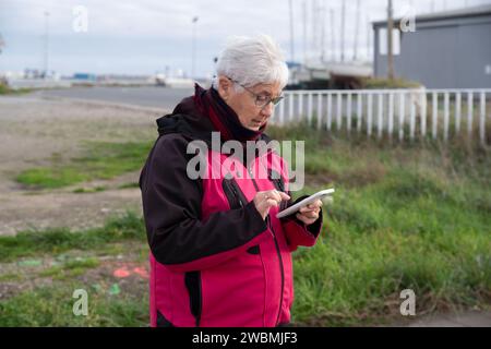 Portrait of a senior woman texting on her smartphone outdoors Stock Photo