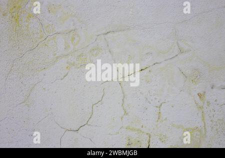 Frosty yellow old paint on a gray wall. Stock Photo