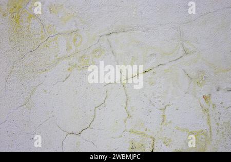 Frosty yellow old paint on a gray wall. Stock Photo