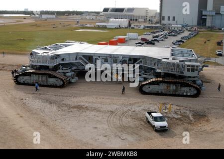 KENNEDY SPACE CENTER, FLA. - Observers walk alongside the newly shod Crawler Transporter as it moves slowly forward. The Crawler Transporter that will move Space Shuttle Discovery to the launch pad for Return to Flight is taking its first road test following the replacement of all its shoes. The crawlers have 456 shoes, 57 per belt (8 belts in all). Each shoe weighs 2,200 pounds. Cracks appeared in the shoes in recent years, spurring a need for replacement. The new manufacturer, in Duluth, Minn., has improved the design for a safe Return to Flight and use through the balance of the Space Shutt Stock Photo