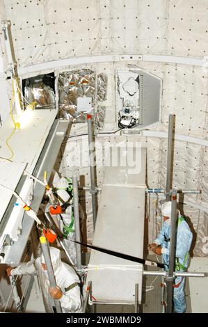 At Launch Complex 39B, technicians build a platform in Discovery’s payload bay to conduct a borescope inspection of the main landing gear retract link assembly as a precaution after a crack was found on Atlantis; the inspection does not affect the STS-114 launch window from July 13 to 31. Stock Photo