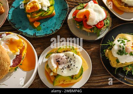 Plates with tasty eggs Benedict on wooden background Stock Photo
