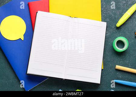 Notebooks with different school stationery on grunge turquoise background Stock Photo