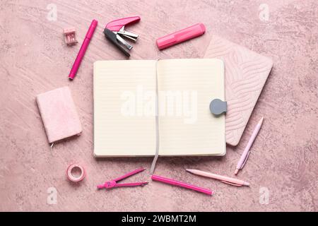 Notebooks with different stationery on grunge pink background Stock Photo