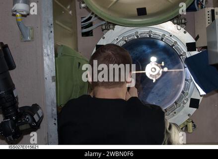 ISS027-E-015621 (22 April 2011) --- Russian cosmonaut Dmitry Kondratyev, Expedition 27 commander, photographs the departure of the unpiloted ISS Progress 41 supply vehicle through a window in the Zvezda Service Module of the International Space Station. Stock Photo