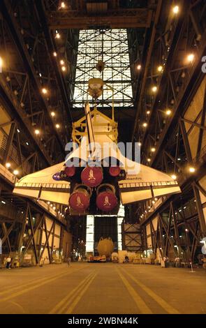 Orbiter Atlantis is raised vertically in the Vehicle Assembly Building ...