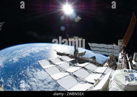 ISS028-E-016140 (12 July 2011) --- This picture, photographed by NASA astronaut Ron Garan during the spacewalk conducted on July 12, 2011, shows the sun and many components of the International Space Station. In this frame the space shuttle Atlantis cannot be seen but is docked just out of frame right and a Russian Soyuz docked to Pirs, below the sun. In the lower right foreground is the Alpha Magnetic Spectrometer (AMS) experiment installed during the STS-134 mission. AMS is a state-of-the-art particle physics detector designed to use the unique environment of space to advance knowledge of th Stock Photo