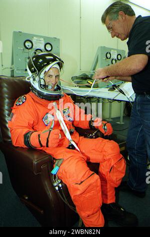 KENNEDY SPACE CENTER, Fla. -- In the Operations and Checkout Building, STS-104 Pilot Charles O. Hobaugh gets help donning his launch and entry suit before heading to the launch pad. This launch will be his first space flight. Liftoff of Space Shuttle Atlantis on mission STS-104 is targeted for 5 04 a.m., July 12, from Launch Pad 39B. The primary payload on the mission is the joint airlock module, which will be added to the International Space Station. The airlock will be the primary path for Space Station spacewalk entry and departure for U.S. spacesuits, and will also support the Russian Orla Stock Photo