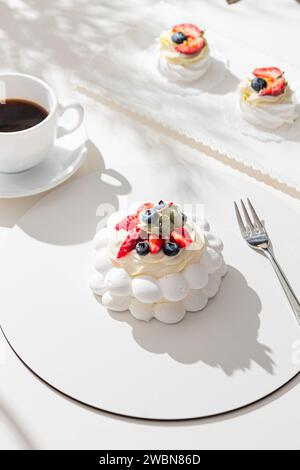 Pavlova meringue cake with fresh berries on white background. Stock Photo