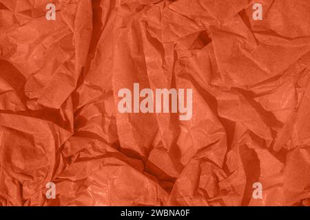 Crumpled paper Peach Fuzz color of the year 2024. Texture crumpled paper for design. Peach background. Trendy abstract wallpaper. Stock Photo