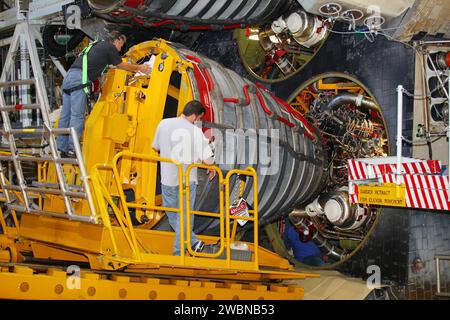 CAPE CANAVERAL, Fla. -- In Orbiter Processing Facility-2 at NASA’s Kennedy Space Center in Florida, technicians monitor the progress as they use a Hyster forklift to position an engine removal device on Engine #3 on space shuttle Atlantis. Inside the aft section, a technician disconnects hydraulic, fluid and electrical lines. The forklift will be used to remove the engine and transport it to the Engine Shop for possible future use. Each of the three space shuttle main engines is 14 feet long and weighs 7,800 pounds. Removal of the space shuttle main engines is part of the Transition and Retire Stock Photo