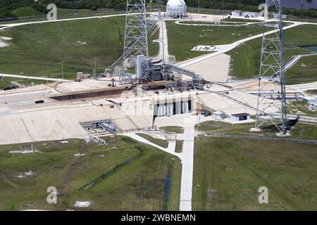 CAPE CANAVERAL, Fla. – An aerial view shows construction progress at Launch Pad 39B at NASA’s Kennedy Space Center in Florida. A new elevator has been constructed on the surface of the pad and the crawlerway leading up to the surface is being repaired. Repairs also are being made to the crawler track panels and catacomb roof below on either side of the flame trench. Also in view are two of the three tall lightning towers that surround the pad. Upgrades are underway at Pad B and other facilities in the Launch Complex 39 area. The Ground Systems Development and Operations, or GSDO, Program offic Stock Photo