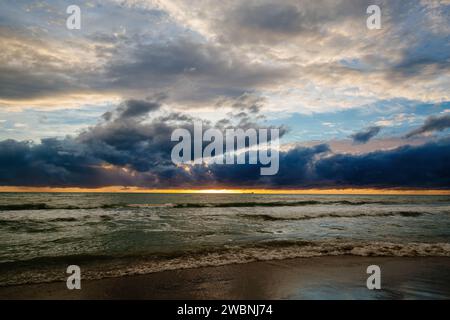 Sunset or dawn on sea. Dramatic cloudy sky. Stock Photo