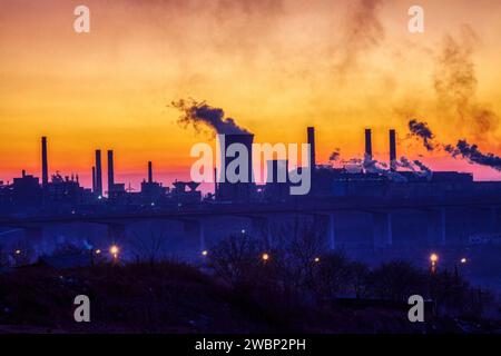 steel factory at sunset causing pollution smoke, global warming issue causing environmental issues ,view over the bridge Stock Photo
