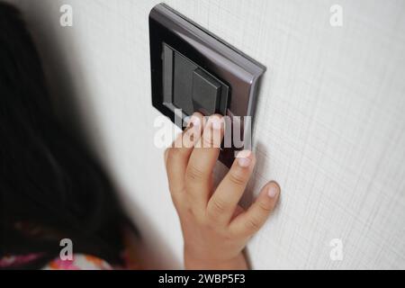 child finger turning on lighting switch with copyspace  Stock Photo