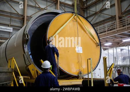 Engineers and technicians process the right forward center segment of the Space Launch System solid rocket boosters for the Artemis II mission inside the Rotation, Processing and Surge Facility (RPSF) at NASA’s Kennedy Space Center in Florida by removing the yellow cap and inspecting propellant on Monday, Nov. 27, 2023. Since arriving via rail in September, the team has been examining each segment one-by-one to make sure they are ready for integration and launch before being moved to the Vehicle Assembly Building for stacking atop the mobile launcher. Artemis II astronauts Reid Wiseman, Victor Stock Photo