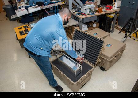 NASA research engineer Jonathan Lopez secures a Compact Fiber Optic Sensing System unit, also known as a FOSS Rocket Box, which was developed at NASA’s Armstrong Flight Research Center in California. The unit is a new variant of aircraft technology that researchers have advanced to withstand the harsh environments of a rocket launch and space travel. Stock Photo
