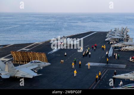 U.S. Navy Sailors participate in flight operations as an F/A-18E Super Hornet fighter jet, attached to the 'Gunslingers' of Strike Fighter Squadron (VFA) 105, launches off the flight deck aboard the aircraft carrier USS Dwight D. Eisenhower (CVN 69) in the Gulf of Oman Nov. 24, 2023. The Dwight D. Eisenhower Carrier Strike Group is deployed to the U.S. 5th Fleet area of operations to support maritime security and stability in the Middle East region. (U.S. Navy photo by Mass Communication Specialist Seaman Nicholas Rodriguez) Stock Photo