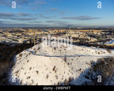 Winter view of Stockholm ski slopes at Hammarbybacken, near the district of Hammarby. Downtown Stockholm in the background. Partly cloudy, snow. Stock Photo