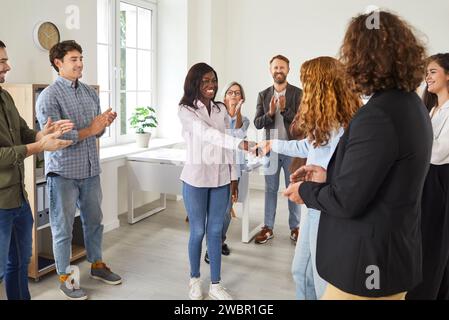 Business people standing in office making deal on meeting. Two happy women shaking hands. Stock Photo