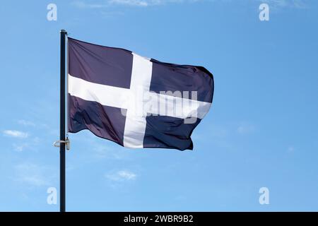 Saint Piran's Flag (Cornwall) waving atop of its pole against a blue sky. Stock Photo