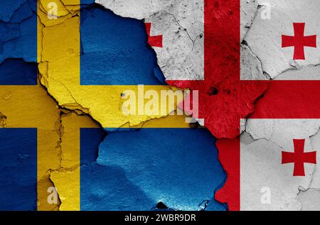 flags of Sweden and Georgia painted on cracked wall Stock Photo