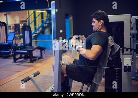 Concentrated man doing strength exercises in a gym Stock Photo