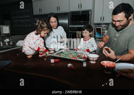 Family of four decorating christmas cookies Stock Photo