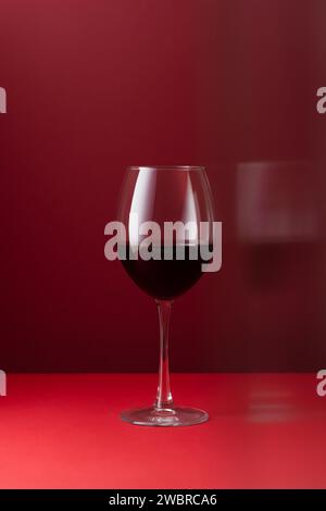 Glass of red wine on a red background art photography Stock Photo