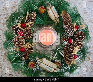 Christmas and new year season, candle between fir sprig, candle, cones and red mushroom heads Stock Photo
