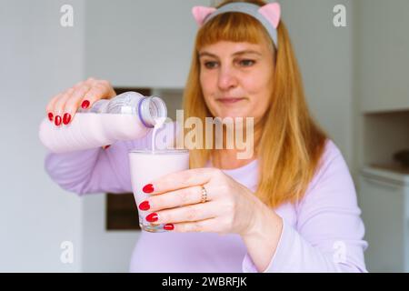 Middle aged woman drinking yogurt Stock Photo