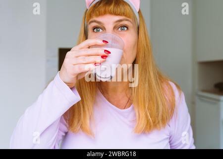 Middle aged woman drinking yogurt Stock Photo