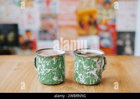 Coffee on vintage Indonesian steel mug with random green pattern called Blirik cup or cangkir Blirik on bokeh background Stock Photo