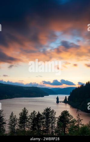 Lake Vyrnwy, located in mid Wales, an area of outstanding natural beauty, at sunset. The orange sky is reflected in the calm water of the lake Stock Photo