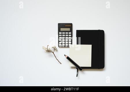 Workspace. black notebook, memopad, calculator, pencil on white desk background. flat lay, top view Stock Photo
