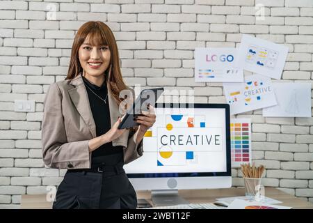 A young Asian graphic designer woman working in a creative dynamic office Stock Photo