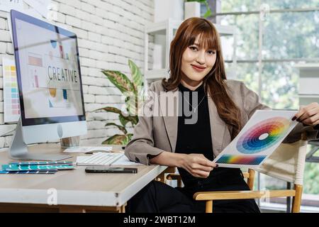 A young Asian graphic designer woman working in a creative dynamic office Stock Photo