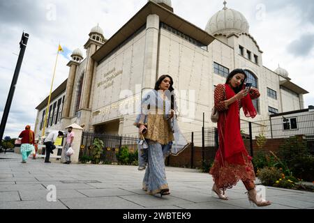 29th August, 2022: Southall, in the borough of Ealing in West London, is home to the largest Punjabi community outside the Indian subcontinent. It has become a hub of Asian culture in the UK, often referred to as Little India. The photograph features Sikh worshippers passing the Gurdwara Sri Guru Singh Sabha temple. Stock Photo