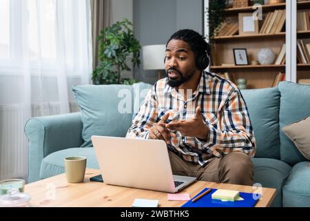 Young African American man healthcare worker psychologist psychotherapist talking online on web conference video call about how to reduce stress and a Stock Photo