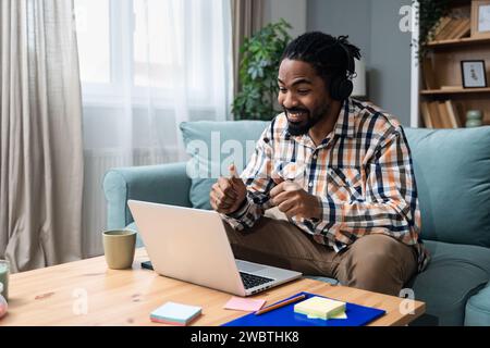Young African American man healthcare worker psychologist psychotherapist talking online on web conference video call about how to reduce stress and a Stock Photo