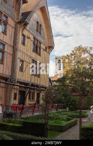 A half-timbered medieval building in the Juvenal des Ursins garden with the Saint Jean-au-Marché church peeking behind, in Troyes, France. Stock Photo