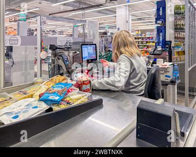 italy - January 12, 2024: Supermarket checkout with cashier passing over product reader purchased in Italian supermarket Stock Photo