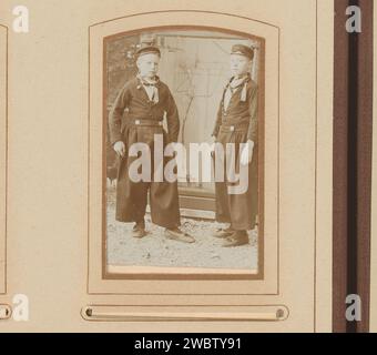 Portrait of two boys in a chicken run, Anonymous, 1880 - 1920 Photograph. visit card This photo is part of an album.  photographic support. cardboard  girl (child between toddler and youth). chicken house Stock Photo